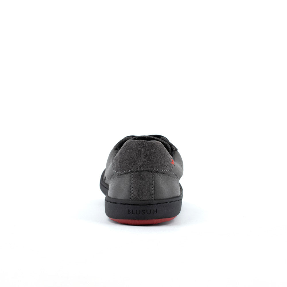 Blusun BLSN‑200 sneakers i mörkgrått, visad från sidan med svarta skosnören, rundad tå och minimalistisk design.