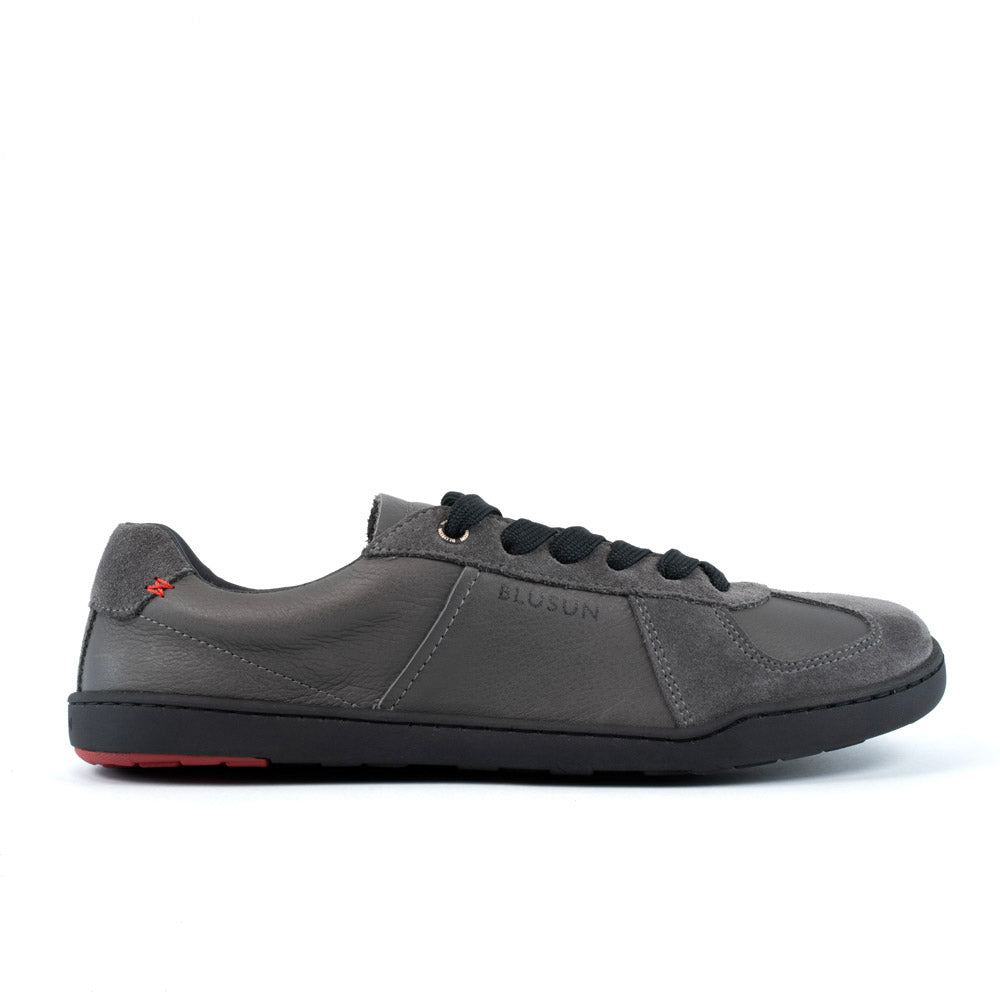 Blusun BLSN‑200 sneakers i mörkgrått, visad från sidan med svarta skosnören, rundad tå och minimalistisk design.
