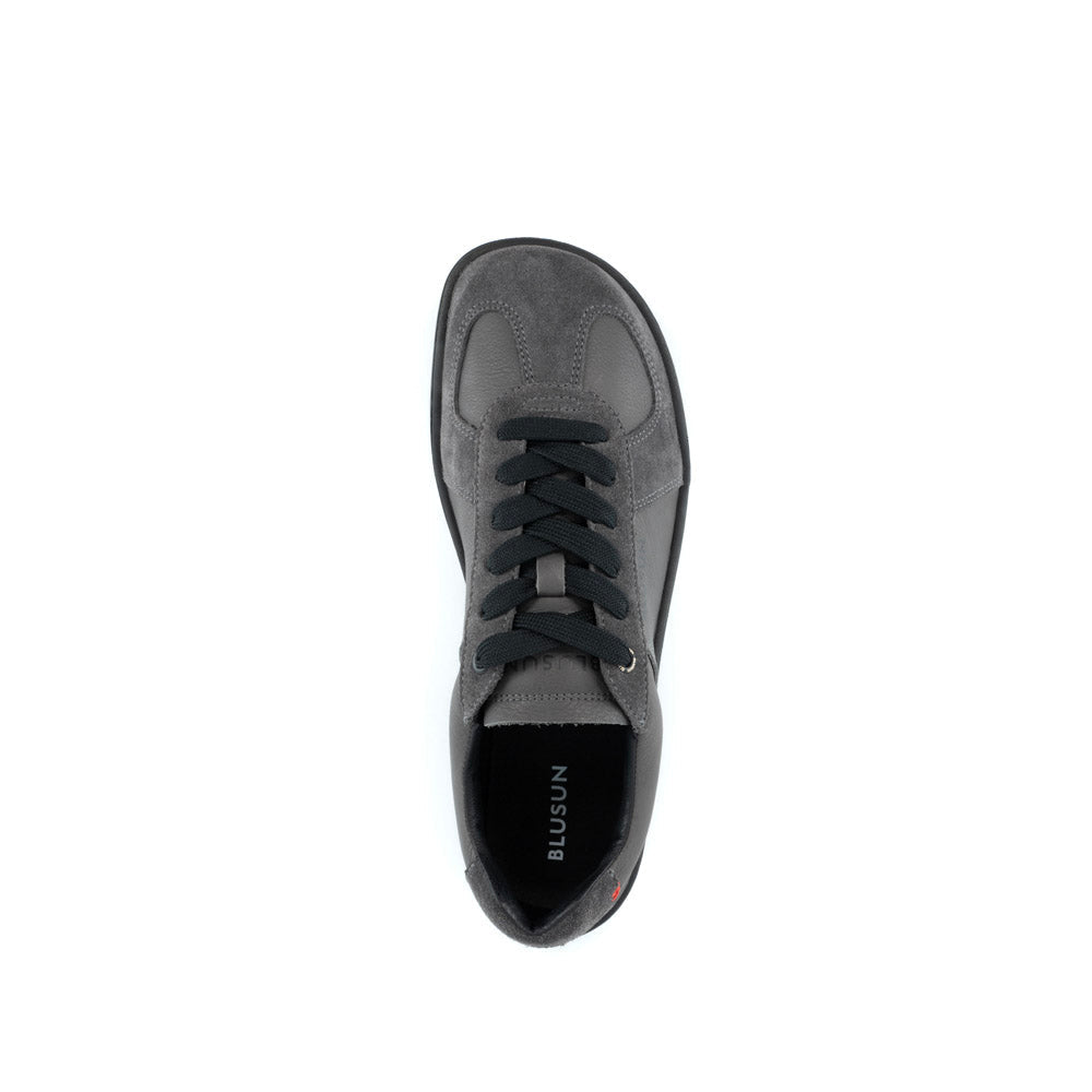 Blusun BLSN‑200 sneakers i mörkgrått, visad från sidan med svarta skosnören, rundad tå och minimalistisk design.