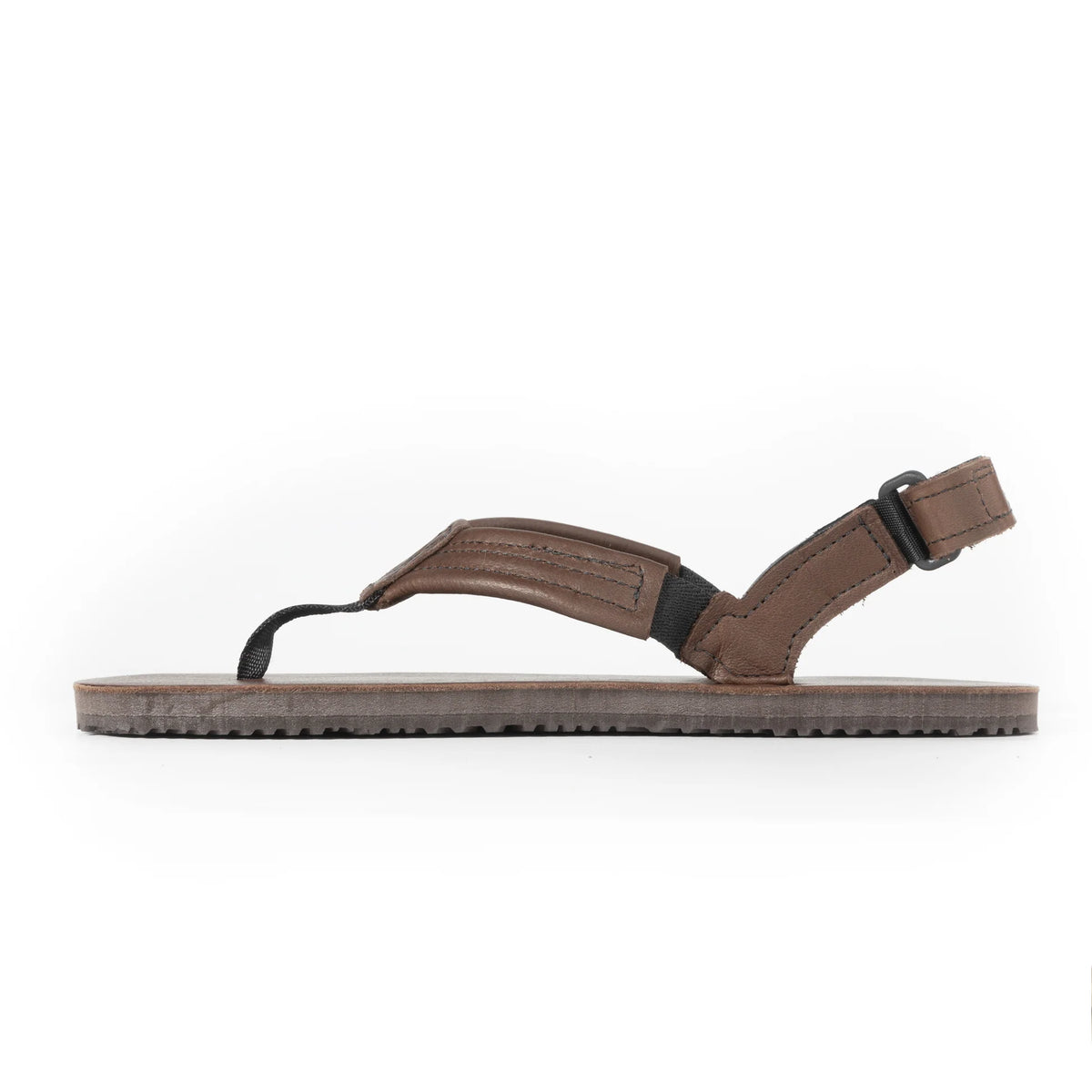 Sidosikt på barfotasko-sandalen Shamma Sandals Pacific Avenue i brunt läder med platt Vibram-sula. Modellen har ett tåfäste i textil, vadderade läderband och justerbar hälrem med plastspänne för optimal passform och naturlig rörelsefrihet.