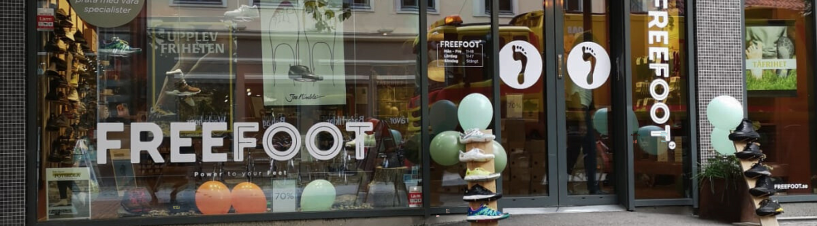 Freefoots butik i Malmö med stora glasdörrar, ballonger och skor på display utanför entrén. Skyltfönstret visar logotypen och flera par skor, samt en tydlig 70 % rea-skylt.