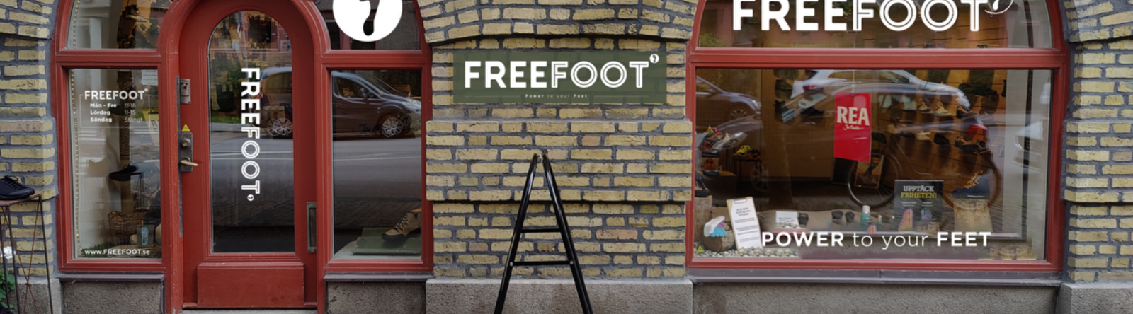 Freefoots butik i Göteborg med gulbrun tegelvägg, röd entrédörr och stora skyltfönster. Logotypen syns tydligt och ett skyltfönster visar en röd rea-skylt samt skor på display.