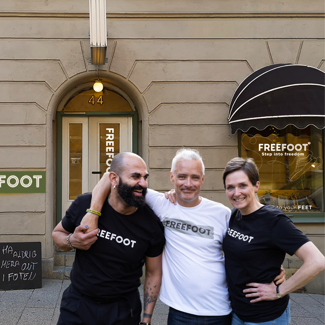 Tre medarbetare från Freefoot står leende framför butikens entré vid nummer 44. De bär Freefoot‑tröjor och poserar avslappnat, vilket ger en varm och välkomnande känsla.