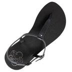 Produktbild på Lonnies sandaler Lux Little Black sedd uppifrån. Den minimalistiska barfotaskon har svarta remmar i T-design, ett justerbart spänne och en slät svart sula med Lonnies logotyp tryckt i hälen. Designad för barfotakänsla med stilren komfort.