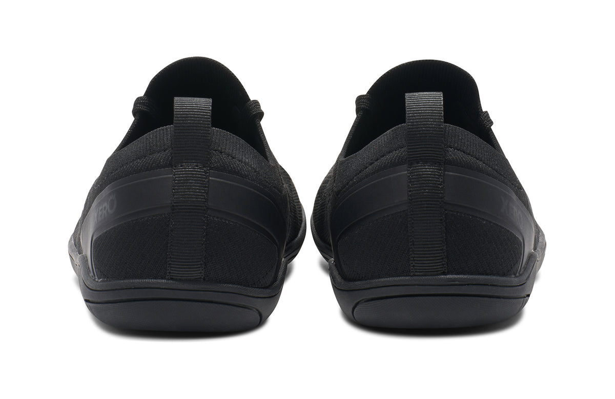 Baksidan av Xero Shoes Nexus Knit Black – helsvart barfotasko i stickad mesh med bred tåbox, noll drop och flexibel yttersula för naturlig rörelse och minimalistisk design.