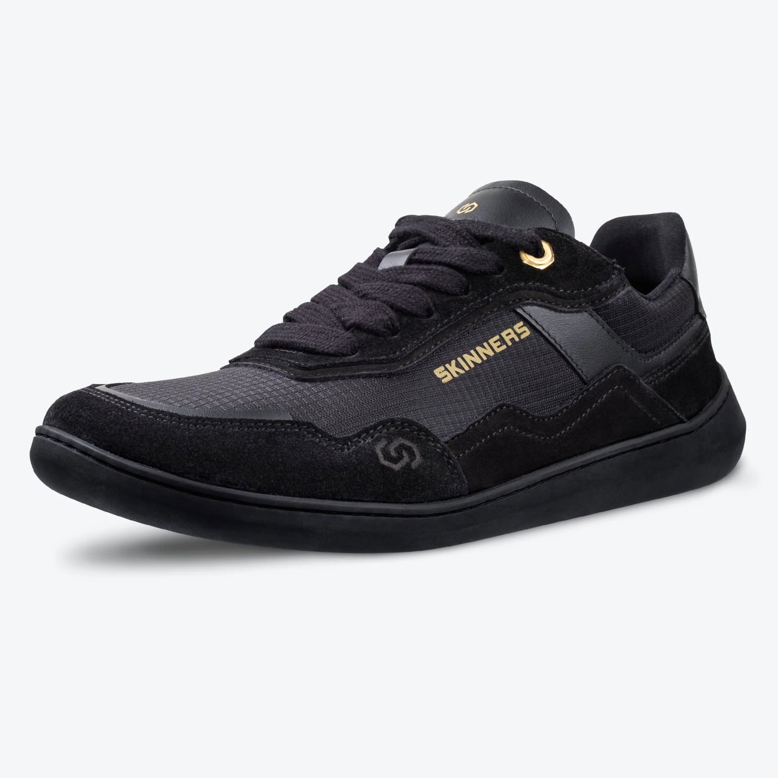Sidovy av barfotasko Skinners Camina Black – svart minimalistisk sneaker med bred tåbox, gulddetalj vid snörning och flexibel sula. Perfekt för naturlig fotrörelse och vardagsbruk.