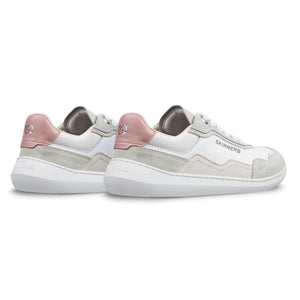 Skinners Camina barfotasko i färgen Pink, visad snett bakifrån. Skon har vit bas, ljusgrå och beige mockadetaljer samt rosa hälparti. Låg profil med bred tåbox och flexibel vit sula – designad för naturlig rörelse och vardagskomfort.