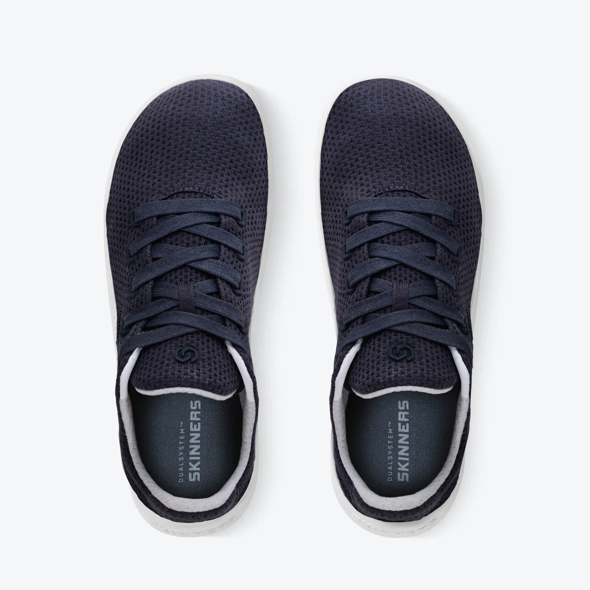Produktbild av Skinners Globetrotter barfotasko i marinblått med vit sula, tillverkad i ventilerande meshmaterial och med subtil logotyp längs sidan.
