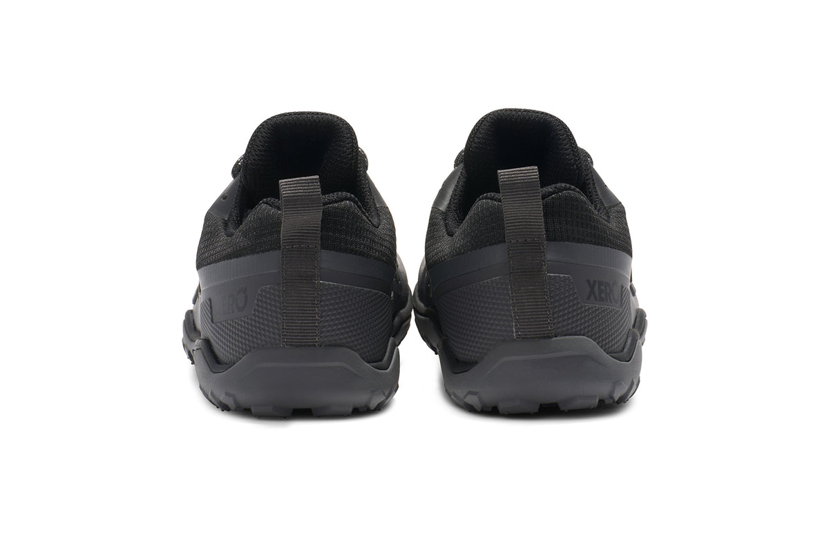 Baksidan av Xero Shoes Scrambler Trail Low WP Black – vattentät barfotasko för terräng, med aggressivt mönstrad sula, bred tåbox och lätt konstruktion för naturlig rörelse i krävande miljöer