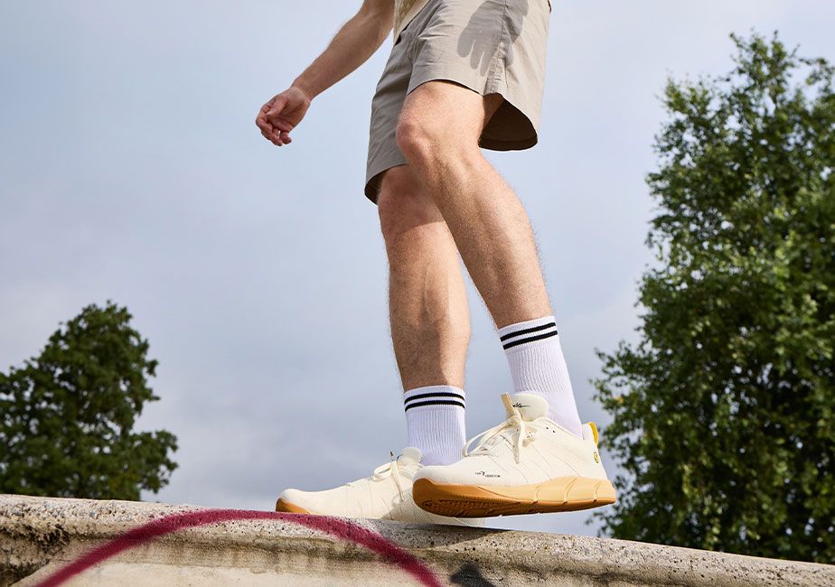 Joe Nimble Addict Road i off-white med guldfärgad sula. Minimalistisk barfotasko med Toe Freedom-design, ventilerande mesh och bred tåbox.